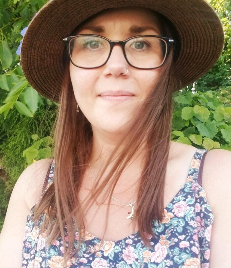 A woman wearing glasses and a hat.